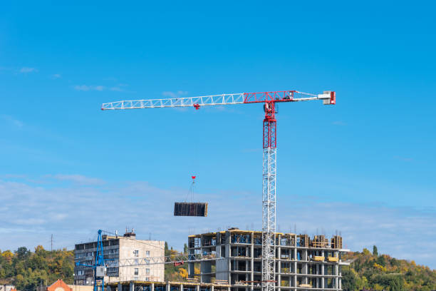 istock Construction crane and a tall building under construction in the background of the mountain 1053932772