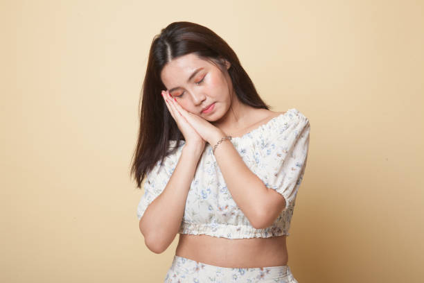 istock Beautiful young Asian woman with sleeping gesture. 1053933814