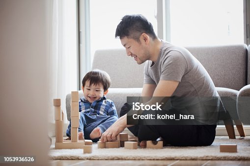 istock Father and son playing with building blocks together 1053936526