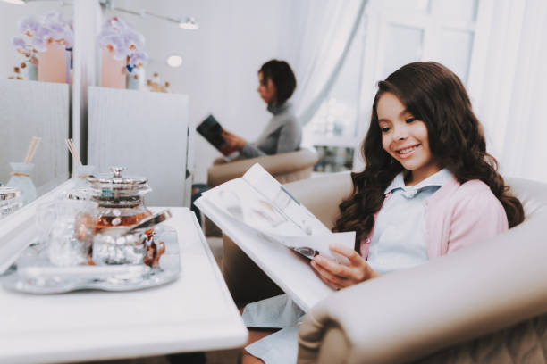 Beautiful Little Girl Reading Magazine in Salon.