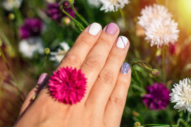 istock Beautiful manicure on a background of flowers 1053941030