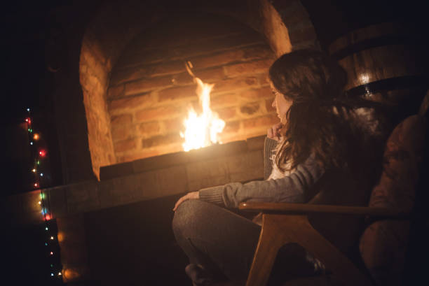 istock Young caucasian girl sitting next to a fireplace 1053953050
