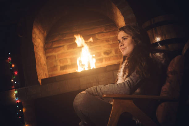 istock Young caucasian girl sitting next to a fireplace 1053953214