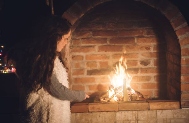 istock Young girl standing next to a fireplace 1053953324