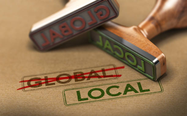 Thinking and Acting Locally, Local Sourcing 3D illustration of two rubber stamps with words global and local over kraft paper background, Concept of consumption manufacturing sourcing stock pictures, royalty-free photos & images