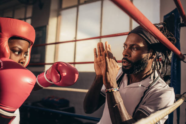 istock Kid wearing boxing gloves and head guard practicing punches 1053960666