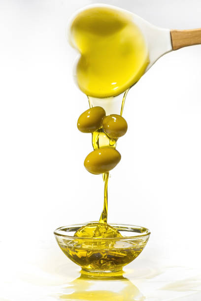 зеленые оливки и оливковое масло с всплеском - cooking oil oil pouring olive oil стоковые фото и изображения