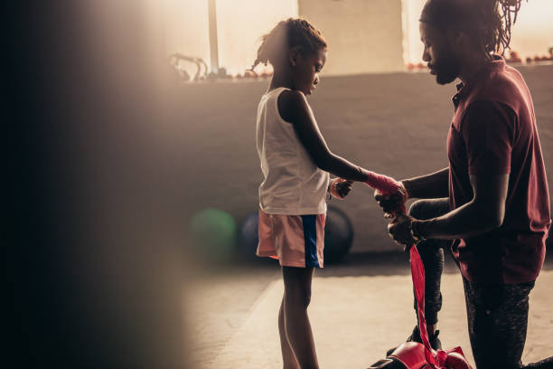 istock Coach wrapping a bandage on the hands of a kid boxer 1053961174