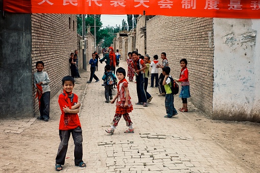 Kashgar / China - MAY 24 2011 : cute young kids going home after school at a chinese village