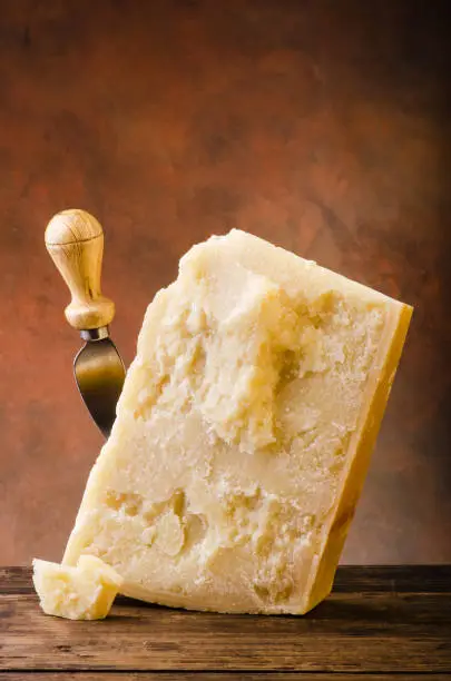 piece of Parmesan cheese, Italian matured cheese with knife. Italian food