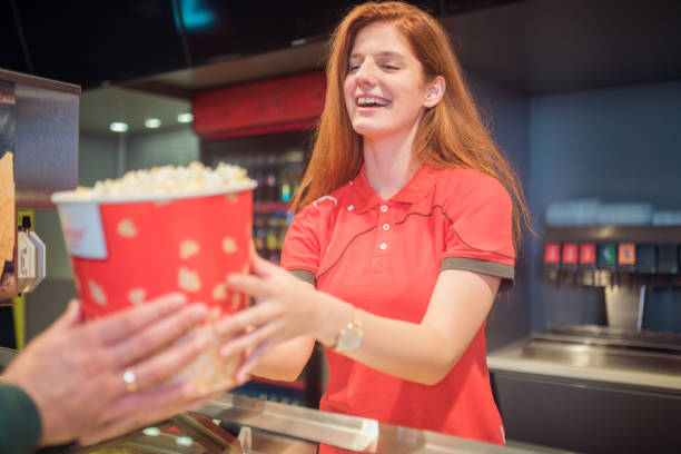 istock Young woman handing popcorn to customer 1053962466