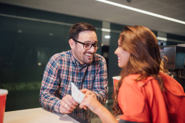 istock Smiling man buying movie tickets 1053963970