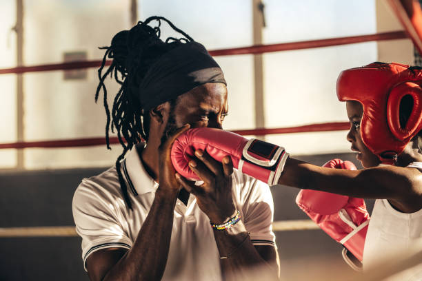 istock Boxing coach teaching a kid how to punch 1053964416