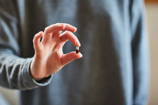 istock Young girl holding a capsule 1053967518