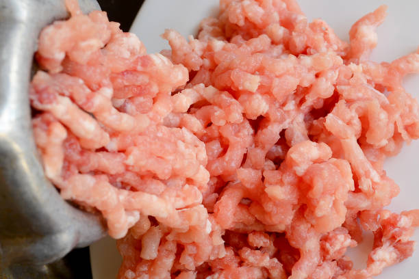 istock Making minced meat with a meat grinder and red raw mince on a white plate, top view 1053979468