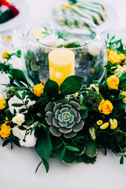 elegante braut und bräutigam tischdekoration für die hochzeit mit kerze herzstück in gelben und grünen farben - wedding centerpiece stock-fotos und bilder