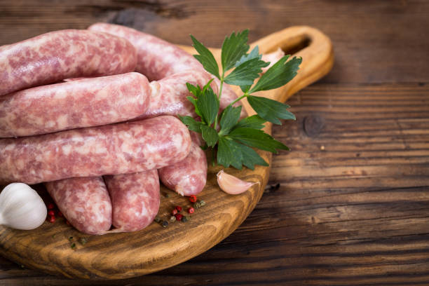 istock Raw sausages on the wooden board 1053985494