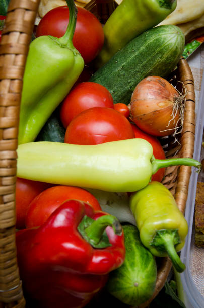 colorful vegetables,onion, cucumber and peppers,  in wooden basket for food festival, close up