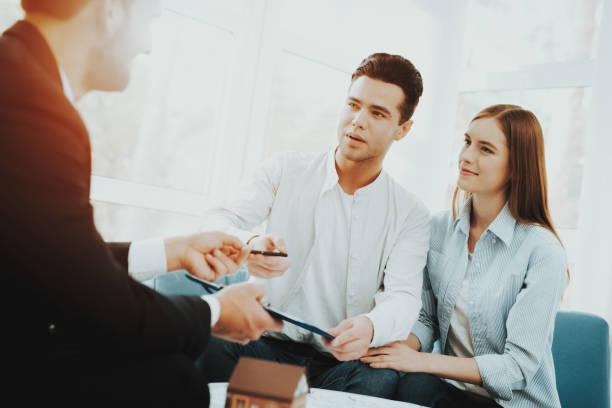 istock Young Couple Meeting With Rieltor. Bright Office. 1053987028