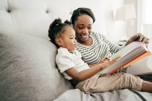 istock Mom and toddler reading a book together 1053987552