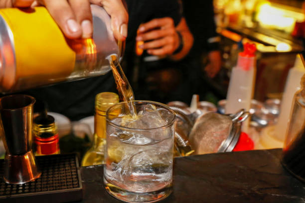 istock Bartender pouring fresh alcoholic drink into glasses.jpg 1053988100