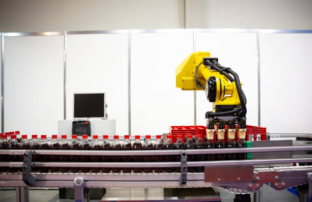 istock Yellow robotic arm soda bottles 1053989888