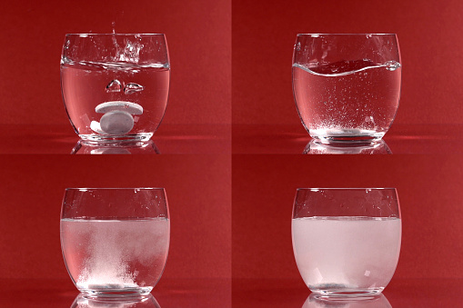 Four images of dissolving effervescent white tablets in a glass of water on a red background.
