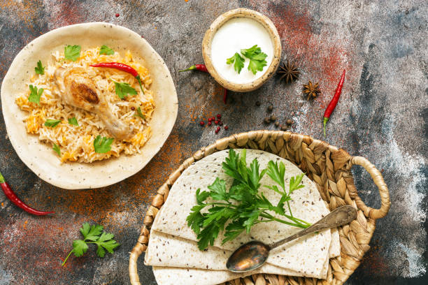 istock Delicious spicy chicken biryani in ceramic bowl on rustic background with spices, Indian or Pakistani food. Top view 1053998068