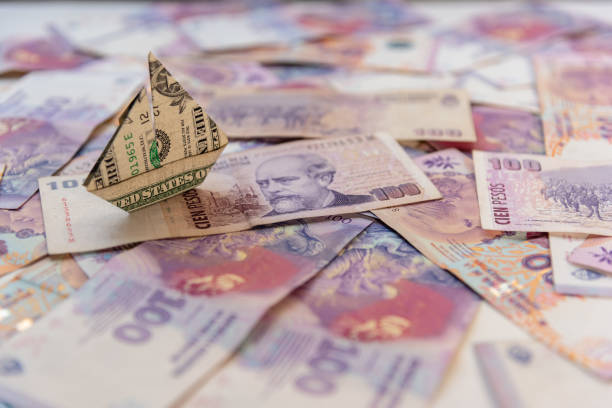 dollaro di origami flotant su uno sfondo di pesos argentini - lautaro foto e immagini stock