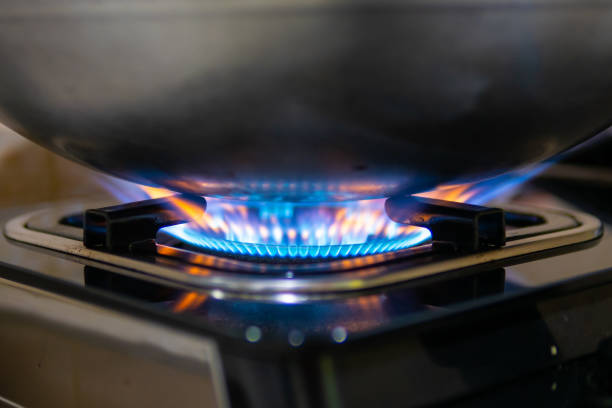 blauer flamme aus gas ofen heizung pfanne beim kochen essen - natural gas gas burner flame stock-fotos und bilder
