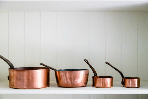 casseroles de cuisine en cuivre debout au comptoir - copper pans photos et images de collection