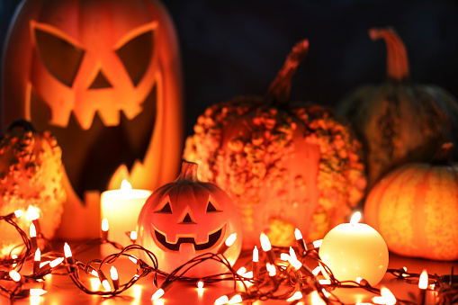 Halloween, autumn scene with pumpkins.  Group of objects includes: candles, pumpkins, jack o' lanterns, and string lights.