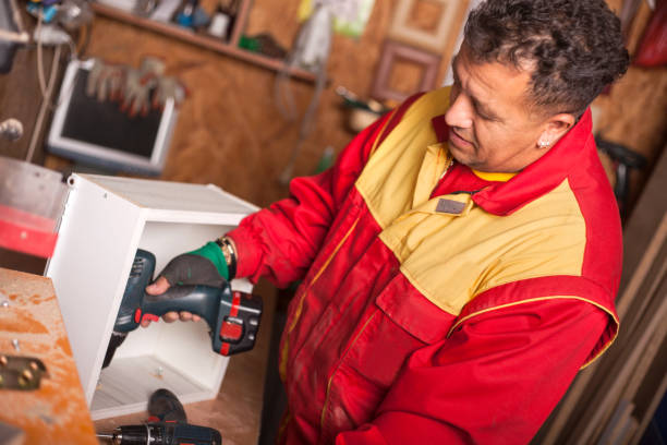 istock Carpenter working with an electric screwdriver on the work bench 1054003878