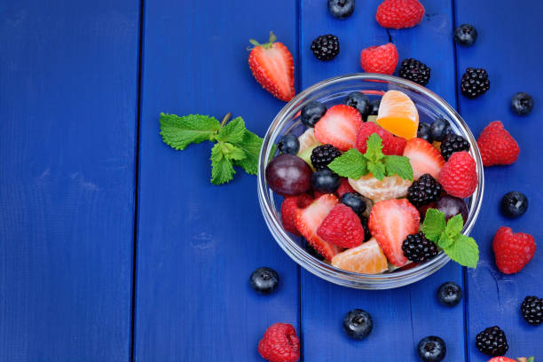 istock Delicious colorful fruit salad in a transparent bowl on table 1054004116