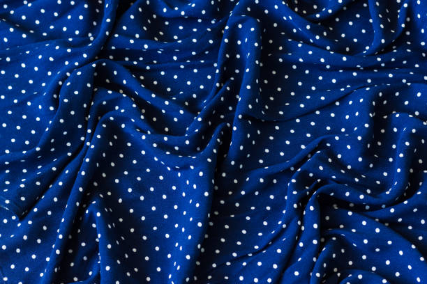 Wrinkled marine blue fabric with white dots
