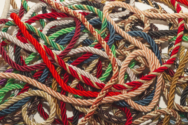 istock Decorative multicolored cords of ropes scattered in a chaotic manner. Textile industry, thread, decoration 1054006984