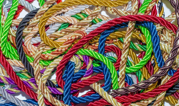 istock Decorative multicolored cords of ropes scattered in a chaotic manner. Textile industry, thread, decoration 1054006994