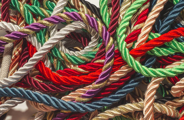 istock Decorative multicolored cords of ropes scattered in a chaotic manner. Textile industry, thread, decoration 1054007014