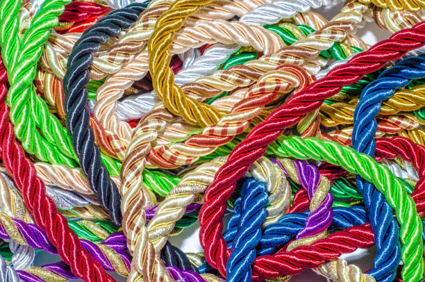 istock Decorative multicolored cords of ropes scattered in a chaotic manner. Textile industry, thread, decoration 1054007036