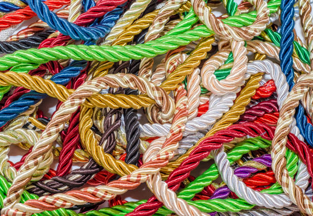 istock Decorative multicolored cords of ropes scattered in a chaotic manner. Textile industry, thread, decoration 1054007074