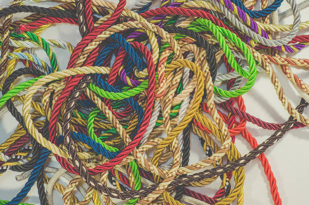 istock Decorative multicolored cords of ropes scattered in a chaotic manner. Textile industry, thread, decoration 1054007090
