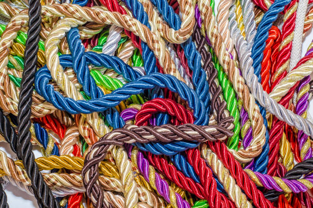istock Decorative multicolored cords of ropes scattered in a chaotic manner. Textile industry, thread, decoration 1054007752