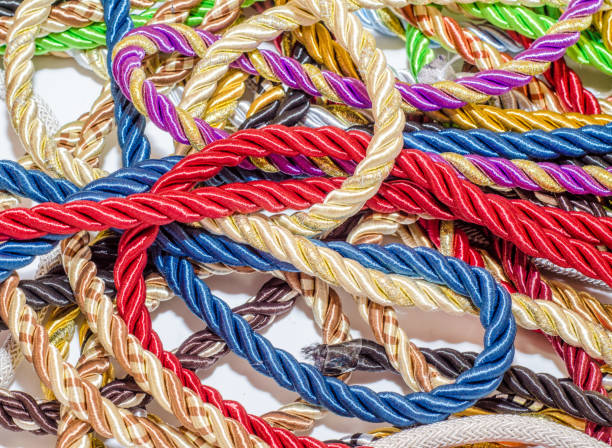 istock Decorative multicolored cords of ropes scattered in a chaotic manner. Textile industry, thread, decoration 1054008154