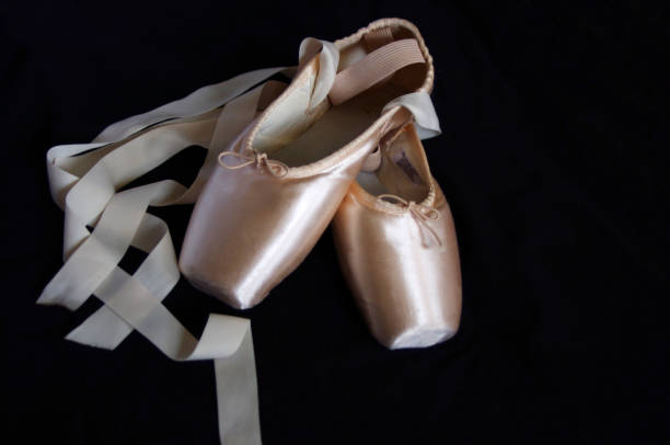 istock Pink ballet Pointe shoes with ribbons on black background 1054008532