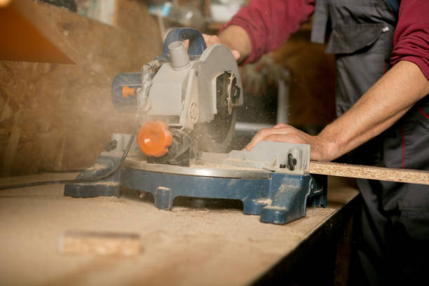 istock Skilled carpenter cutting a piece of wood in his woodwork workshop, using a circular saw 1054009392