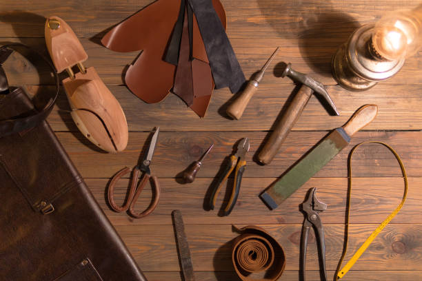 istock tools for making shoes lie on a wooden table. Set of items symbolizing manual labor, small business 1054009664