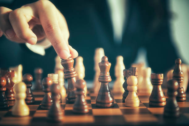 istock Business man moving chess figure with team behind - strategy or leadership concept 1054009768