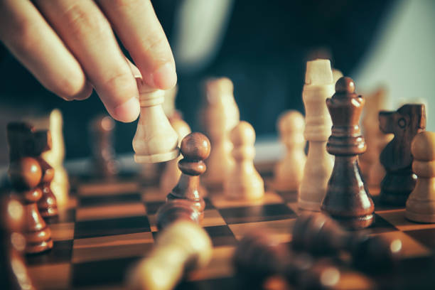 istock Business man moving chess figure with team behind - strategy or leadership concept 1054009786