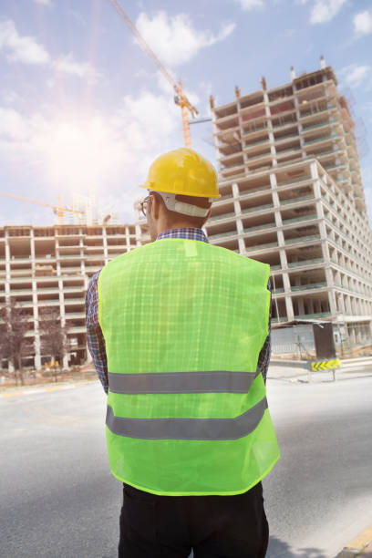istock Young Engineer portrait with construction site and crane background. 1054019246
