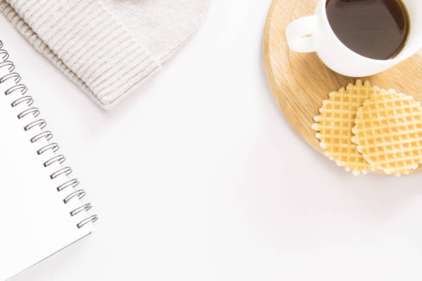 istock A cup of coffee, waffles, hat, and note on grey background. 1054034740